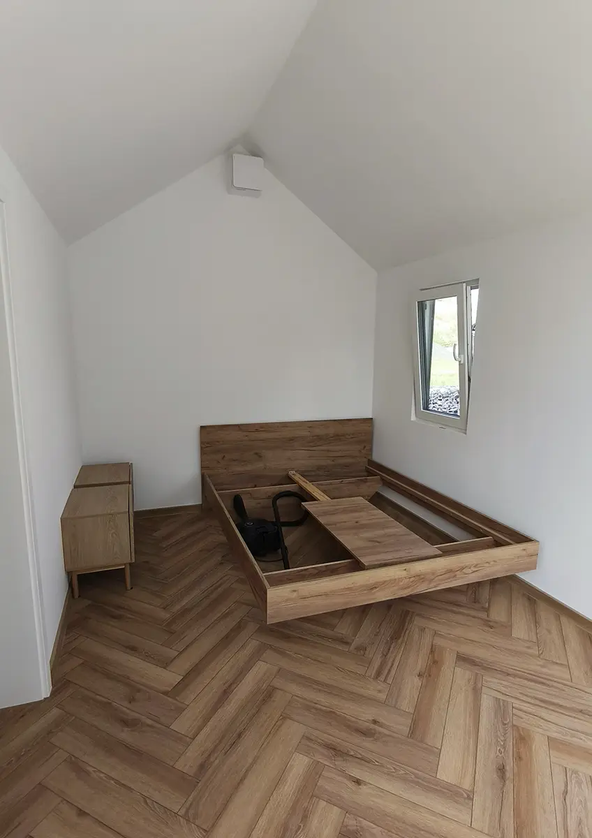 Sypialnia w domu modułowym klienta for.rest house z podłogą i oknem.